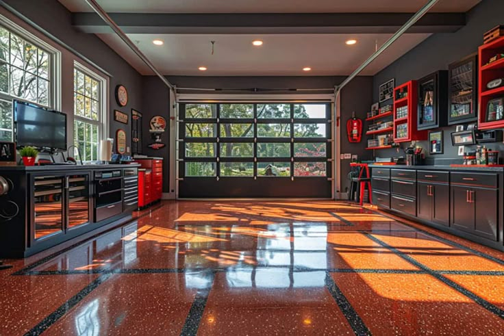 a large kitchen with red cabinets and black appliances on the walls, along with an orange tiled floor