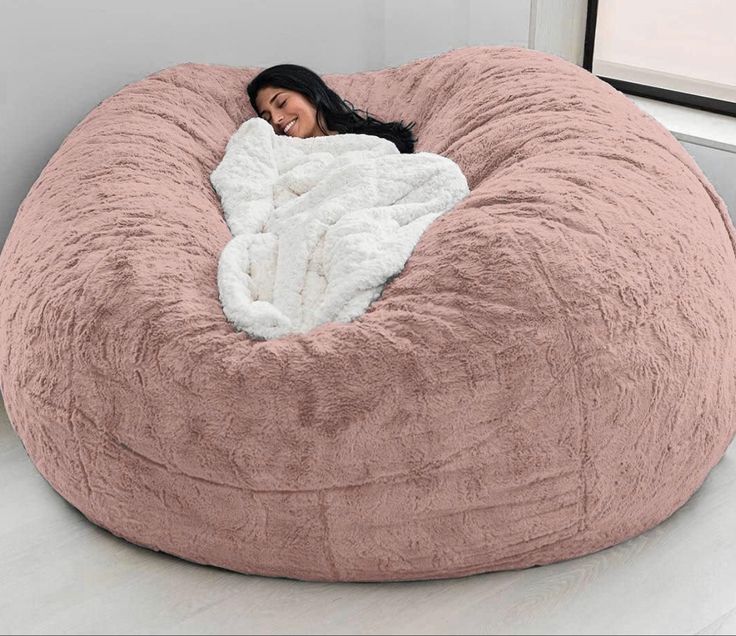 a woman laying in a large bean bag chair