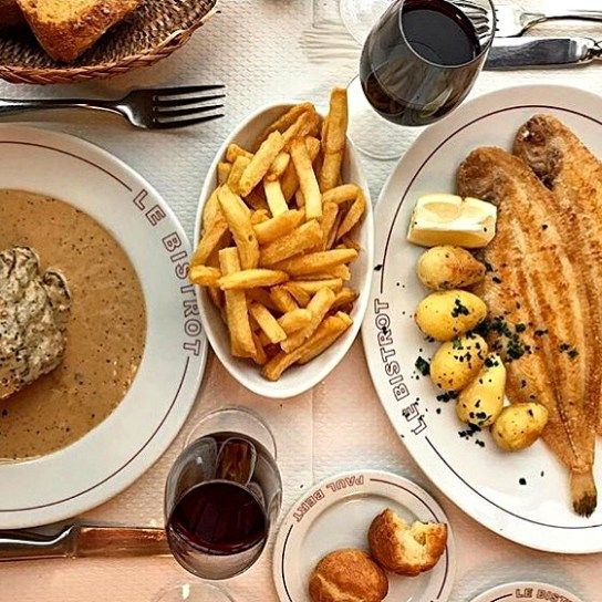 a table topped with plates of food and french fries