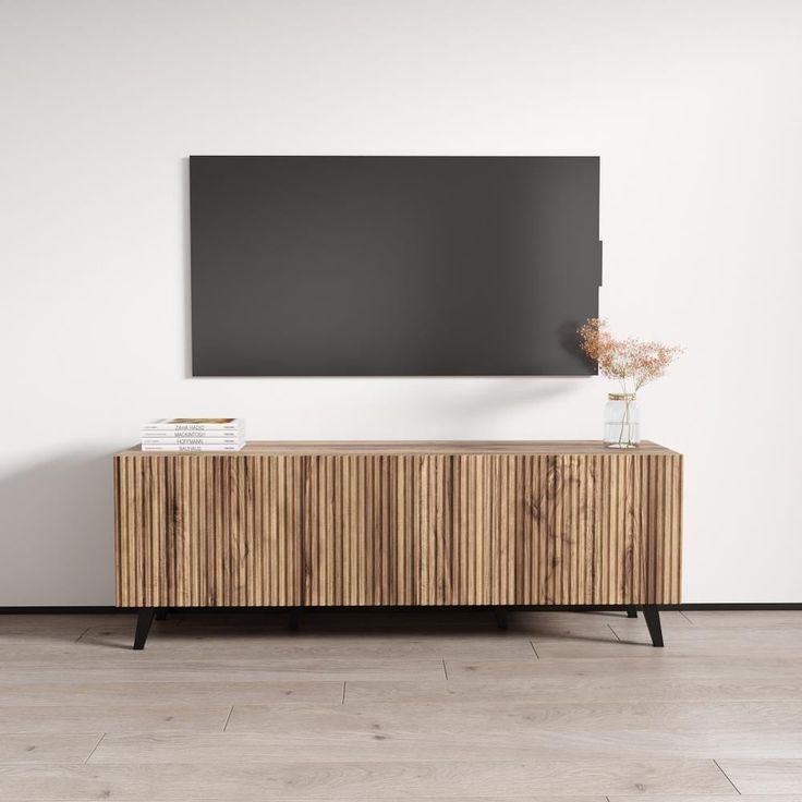 an empty room with a wooden cabinet and a black board on the wall above it