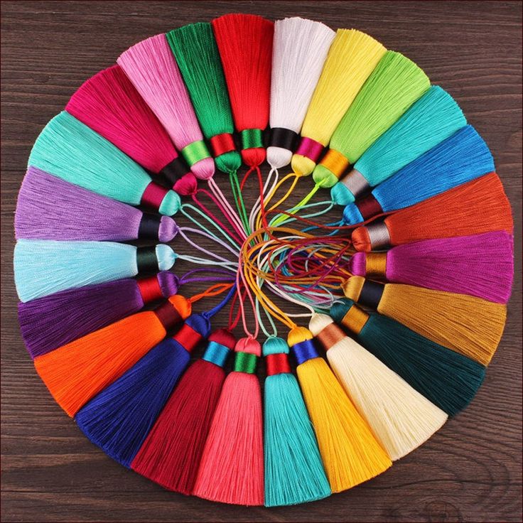 the colors of yarn are arranged in a circle on top of a wooden table,