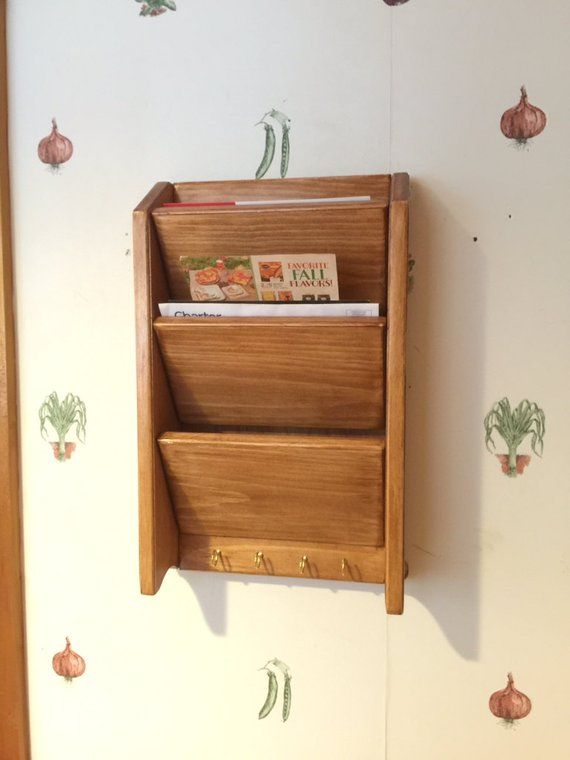 a wall mounted wooden magazine rack on the side of a wall