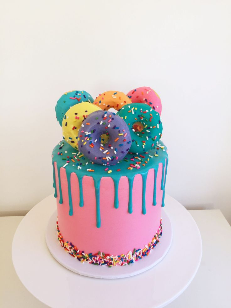 a colorful cake with sprinkles and donuts on top