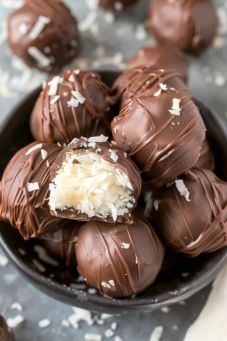 a bowl filled with chocolate covered truffles on top of a gray table