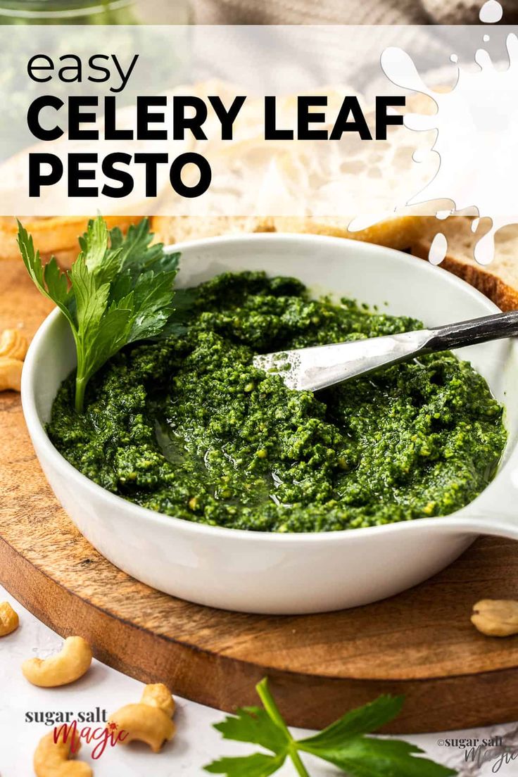 a white bowl filled with pesto on top of a wooden cutting board