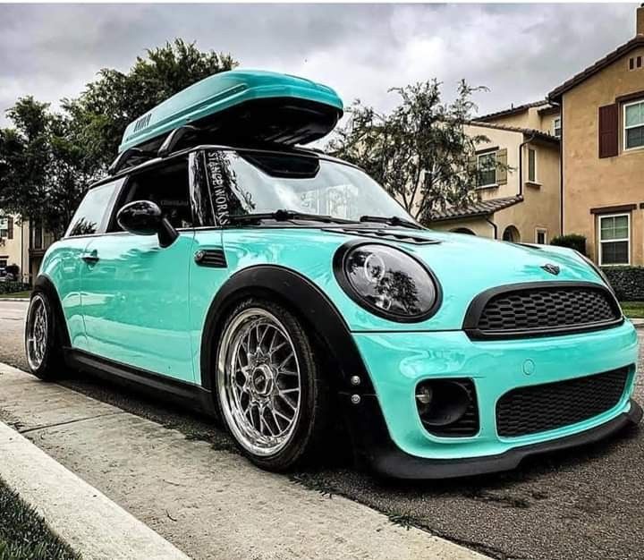 a blue mini with a surfboard on the roof