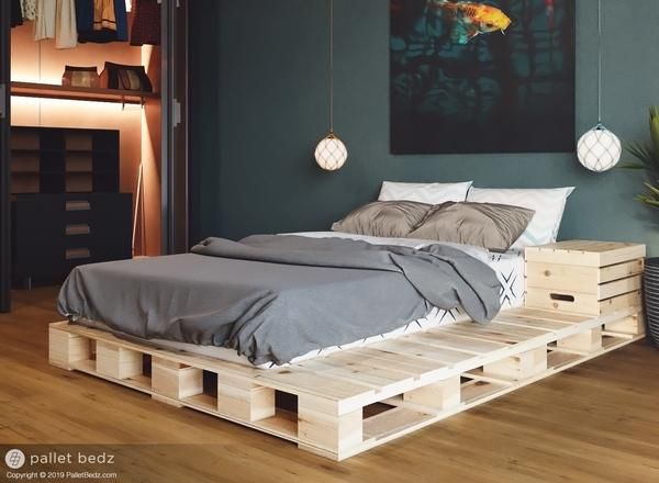 a bed made out of wooden pallets in a room with green walls and wood flooring