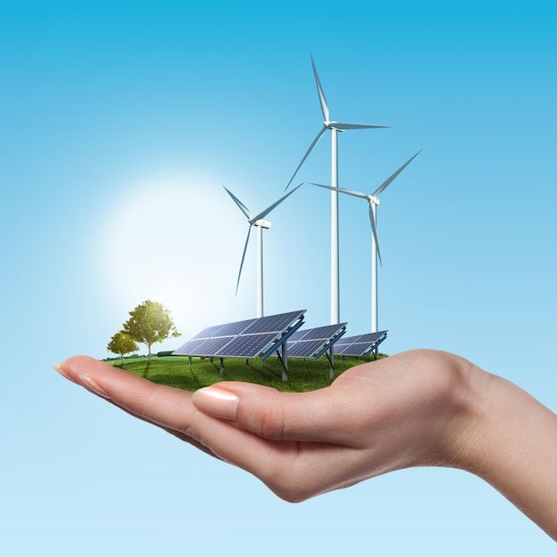 a hand holding solar panels and wind turbines