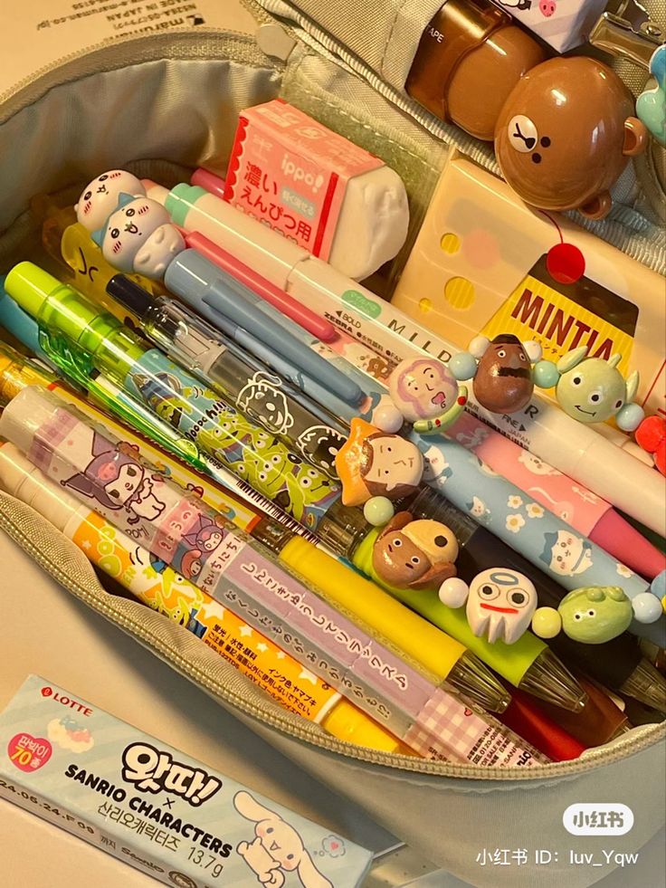 a bag filled with lots of different types of pens and pencils on top of a table