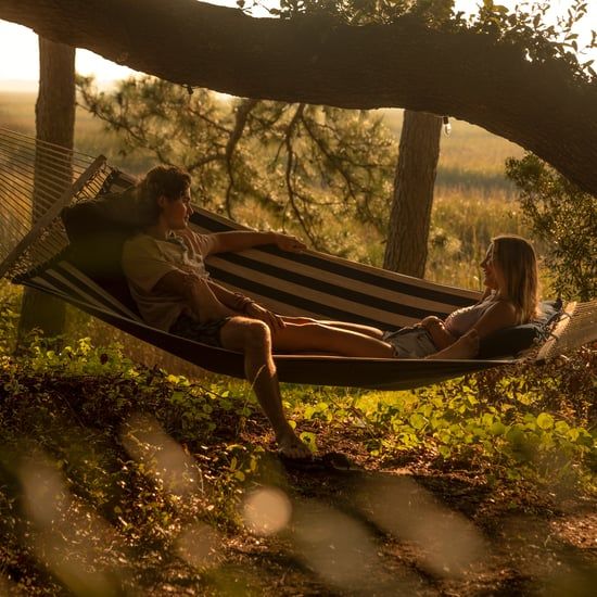 a man and woman sitting in a hammock