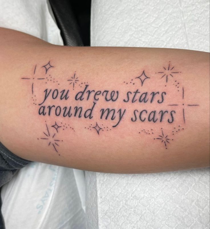 a person with a tattoo on their arm that says, you drew stars around my scars