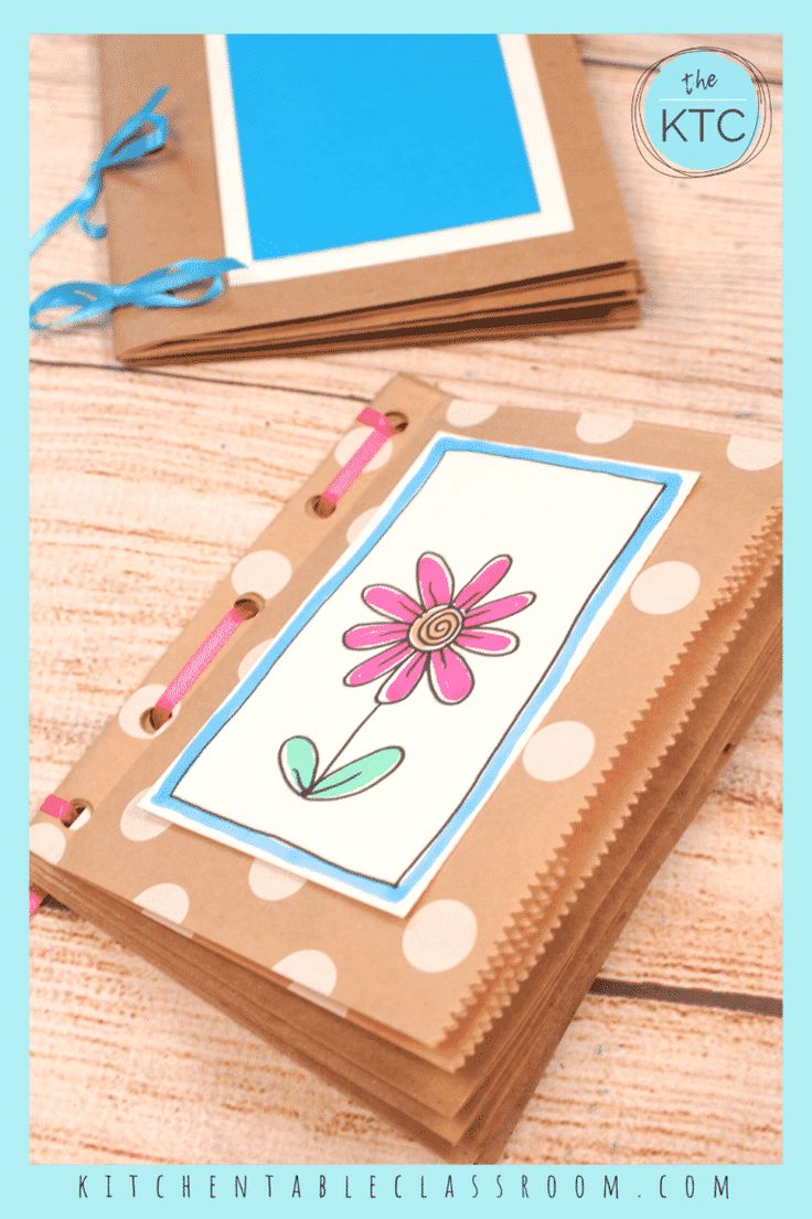 an open notebook with a flower drawn on it and the cover is made out of brown paper