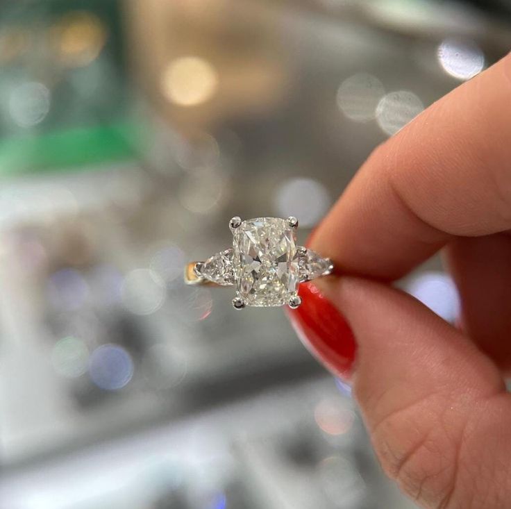 a woman's hand holding an engagement ring