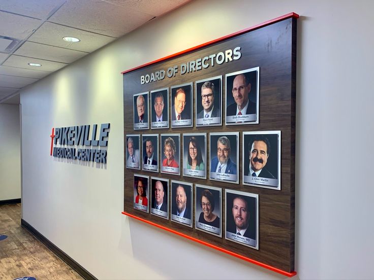 an office wall with pictures on it and the words board of directors written in large letters