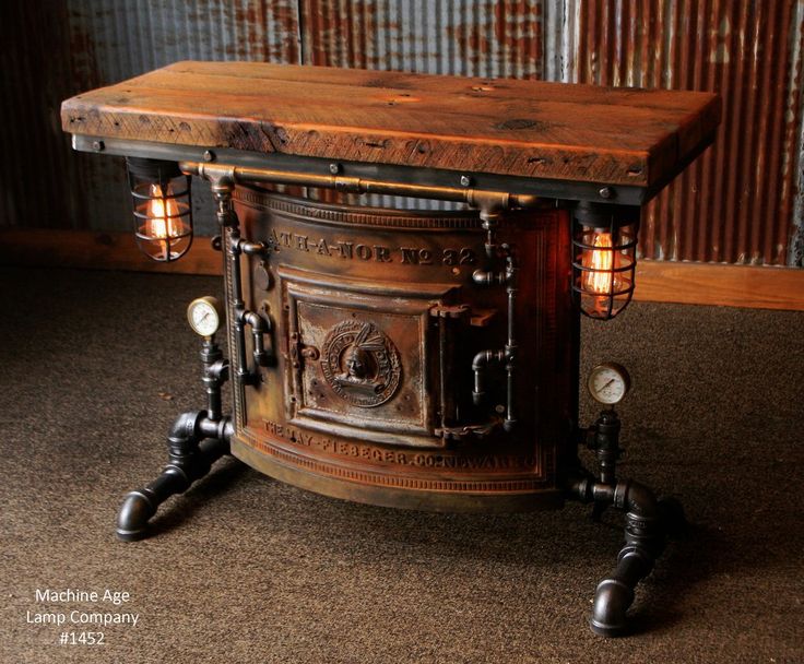 an old fashioned stove with two lights on it's sides and a wooden table top