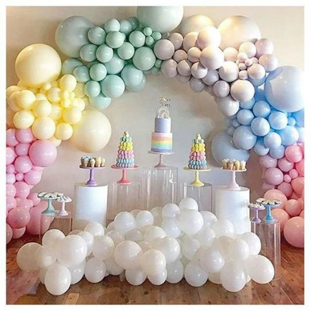 a table topped with lots of balloons and cake