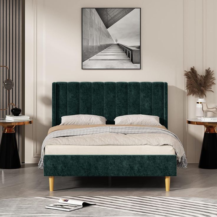 a bed with green velvet headboard and foot board in a white walled bedroom area