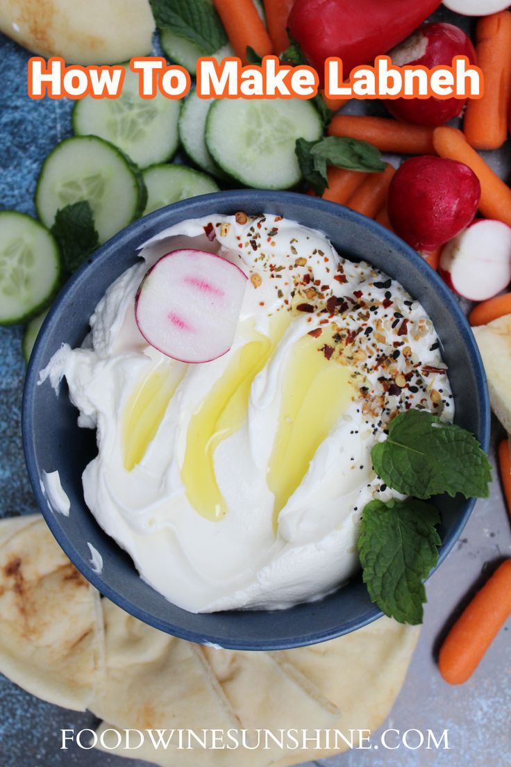 a blue bowl filled with whipped cream surrounded by sliced vegetables and cucumber slices