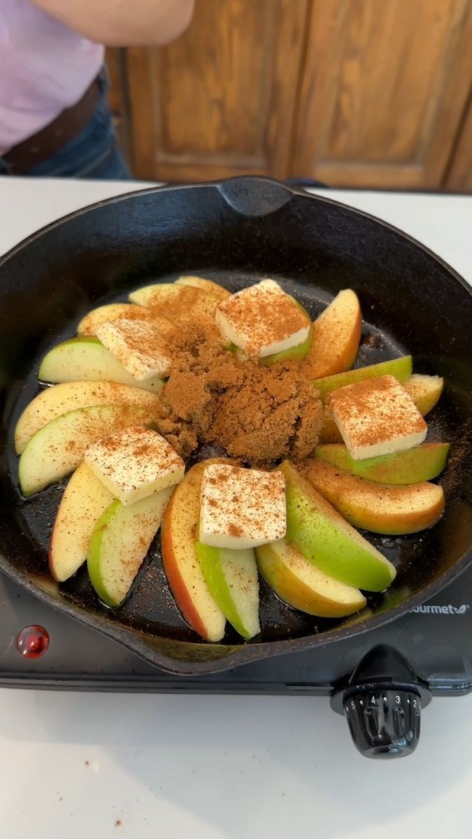 an iron skillet with apples and cinnamon in it