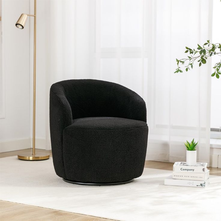 a black chair sitting on top of a hard wood floor next to a white rug