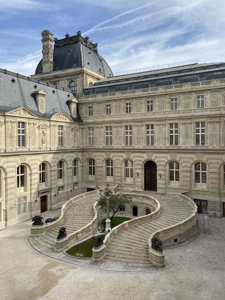 a large building with stairs leading to the top floor and two towers on each side