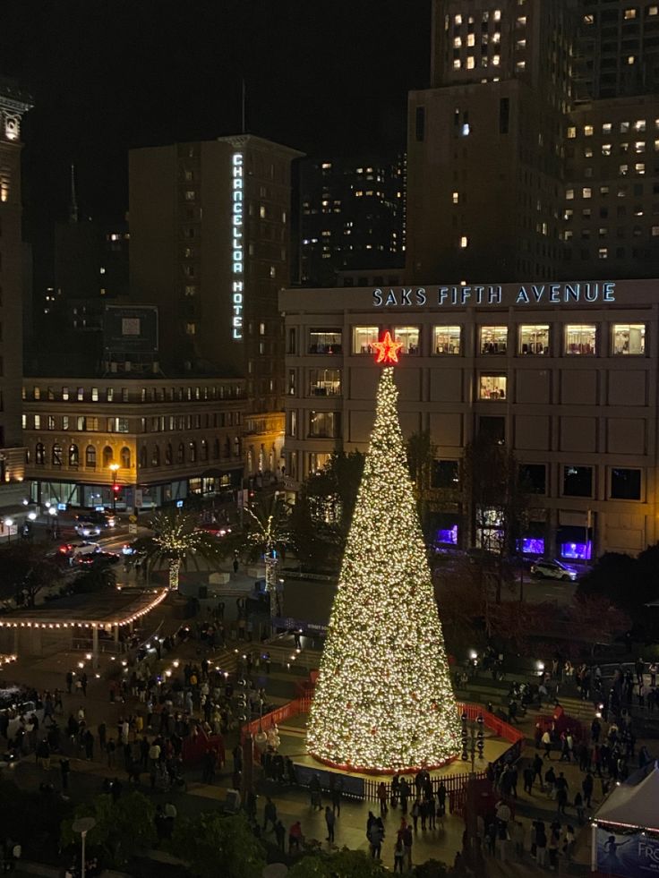 a large christmas tree is lit up in the city