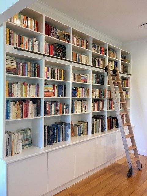 a ladder leaning up against a bookshelf filled with lots of bookcases