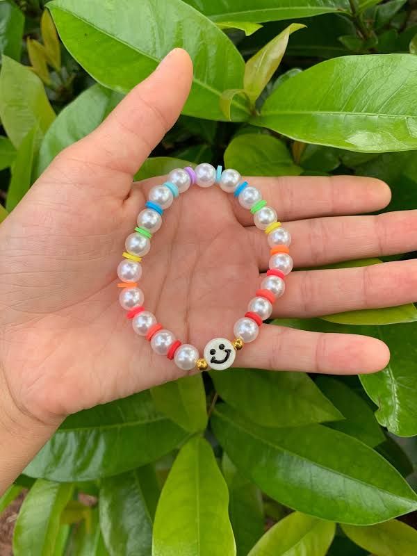 a person's hand with a beaded bracelet on it