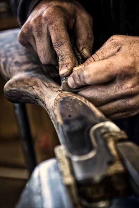 an old man is working on something with his hands and nails in the process of carving