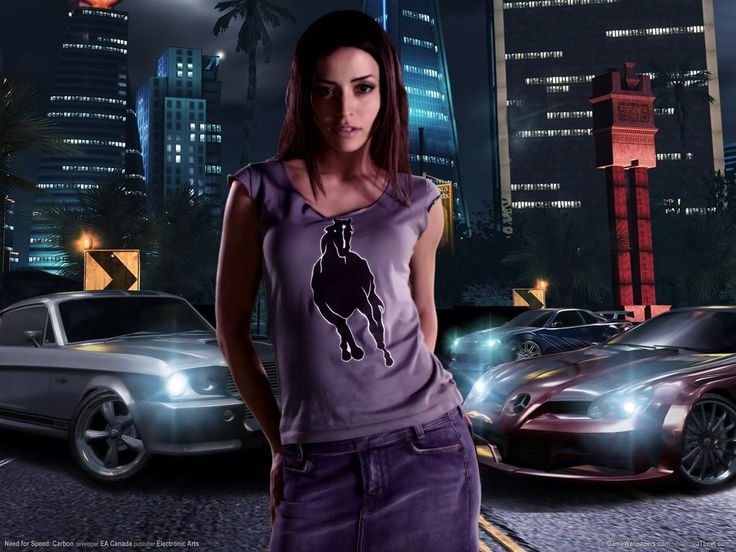 a woman is standing in front of some cars at night with her hands on her hips