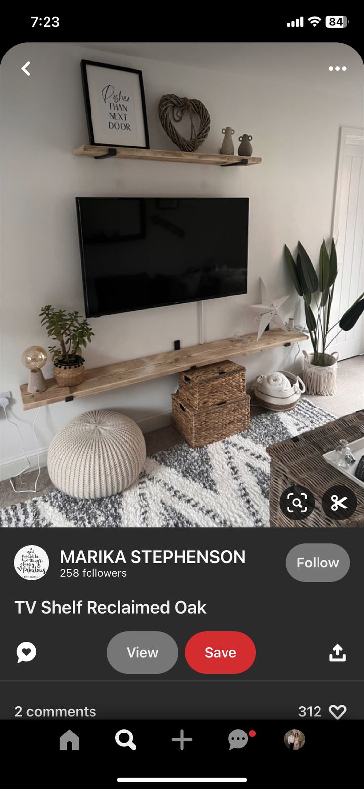 a flat screen tv sitting on top of a wooden shelf