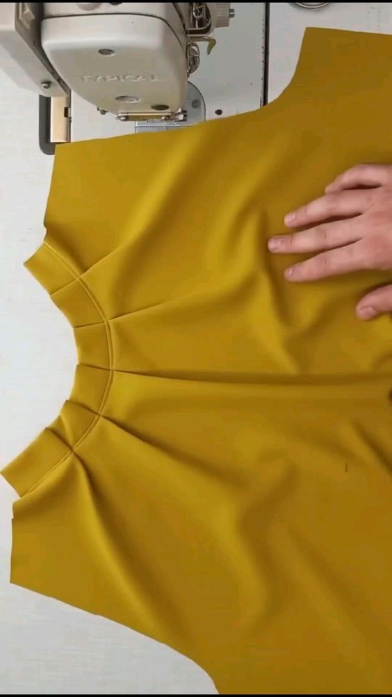 someone is cutting out the back of a yellow dress