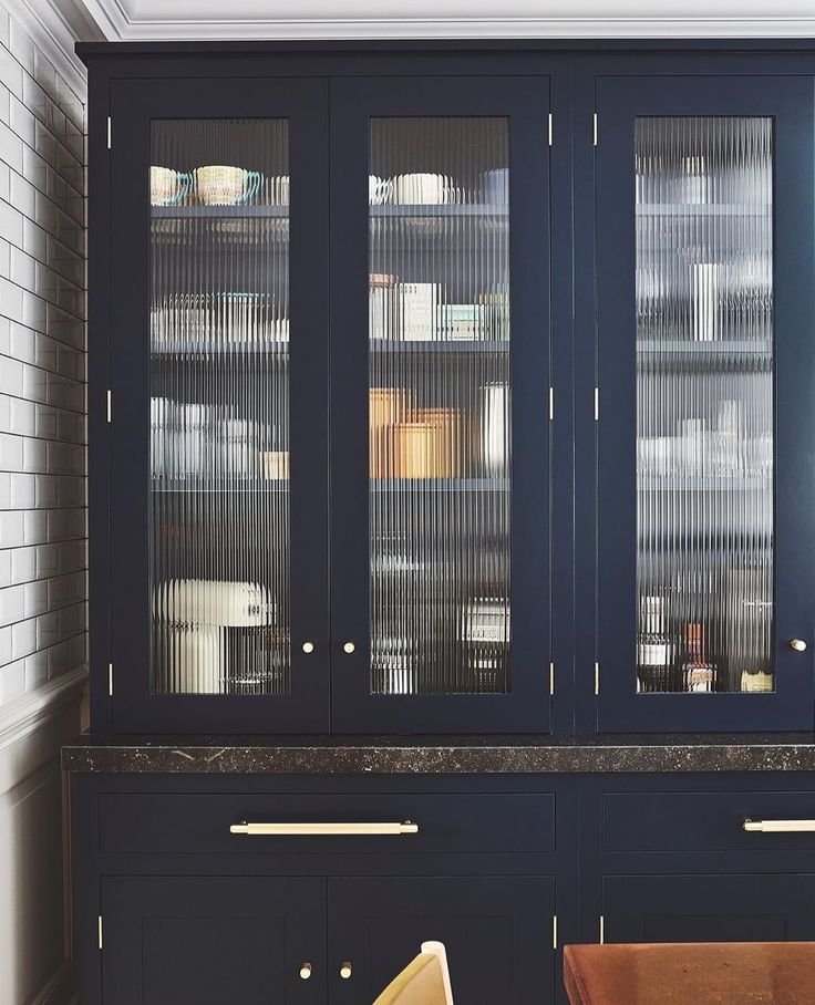 a blue cabinet with glass doors in a kitchen