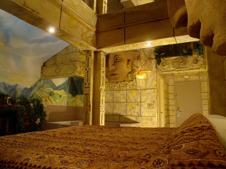 a large bed sitting under a painting next to a wall with paintings on the walls