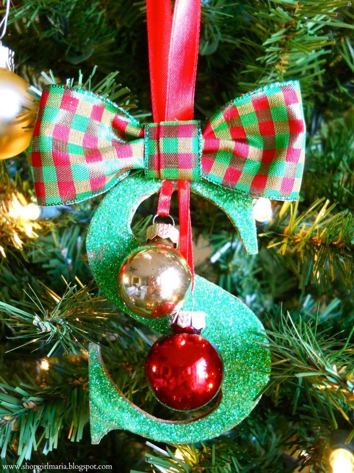 an ornament hanging from a christmas tree decorated with green and red plaid ribbon