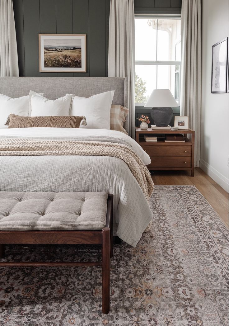 a bedroom with a bed, dressers and window in it's center area