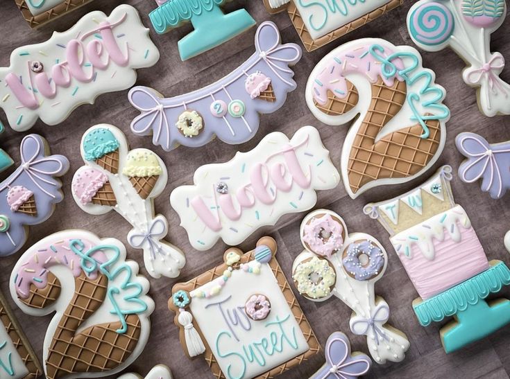 decorated cookies are displayed on a table with the words sweet as ice cream written in blue, pink and white