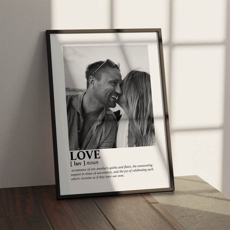 a black and white photo frame with an image of a man kissing a woman's forehead