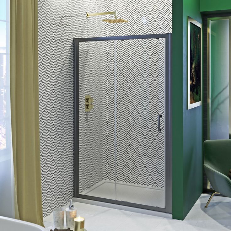 a bathroom with green walls and a white bathtub next to a walk in shower