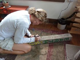 a woman sitting on the floor with a bat in her hand and looking at it