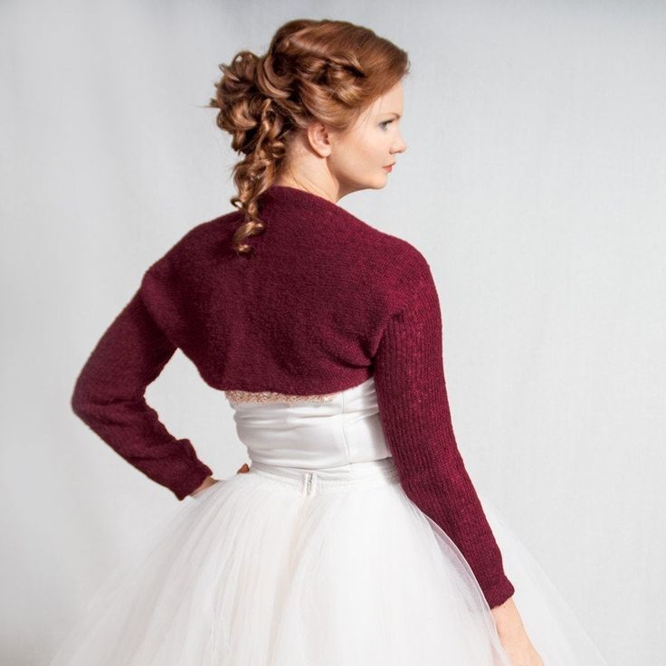 a woman wearing a white tulle skirt and a red cardigan over her shoulders