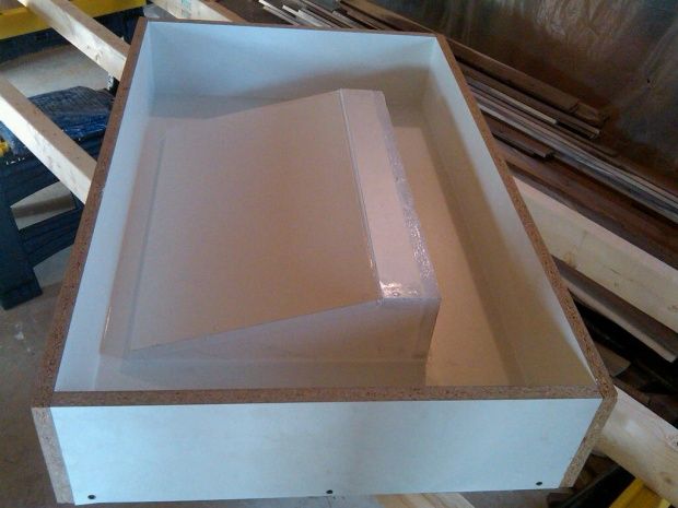 a large white box sitting on top of a wooden table next to other wood planks