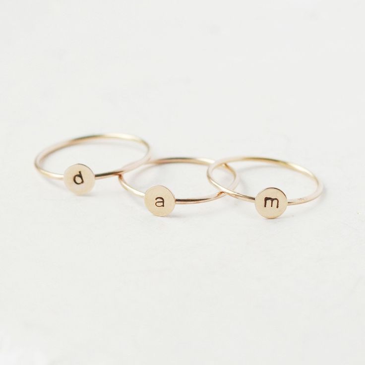 One gold letter ring. Personalize a gift she'll treasure with our gold initial ring. An adorably petite initial, imprinted on a 14k gold filled disk - paired with a super skinny (1mm) gold filled band - creates the perfect stacking ring, customized with your monogram. Lovely as a stand alone. Also sits beautifully with multiple initials stacked or our hammered gold stacking ring bands. This gold initial ring arrives custom made to order in your size hand stamped with the letter of your choice. A Initial Ring Gold, Gold Initial Ring, Rose Gold Initial, Gold Stacking Ring, Ring Bands, Letter Ring, Stacking Ring Set, Gold Letter, Gold Monogram