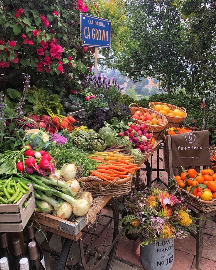 an outdoor market with lots of fresh vegetables and fruits on display for sale in baskets