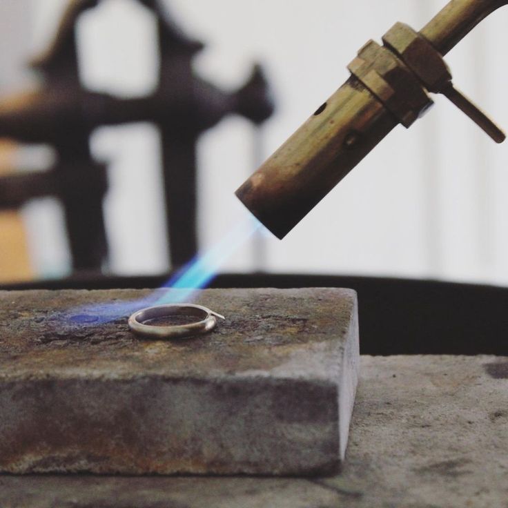 a metal object with a blue flame coming out of it's center, on top of cement blocks