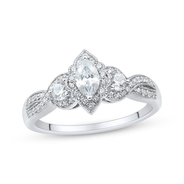 a white gold ring with three pear shaped diamonds on the band and an intricate design