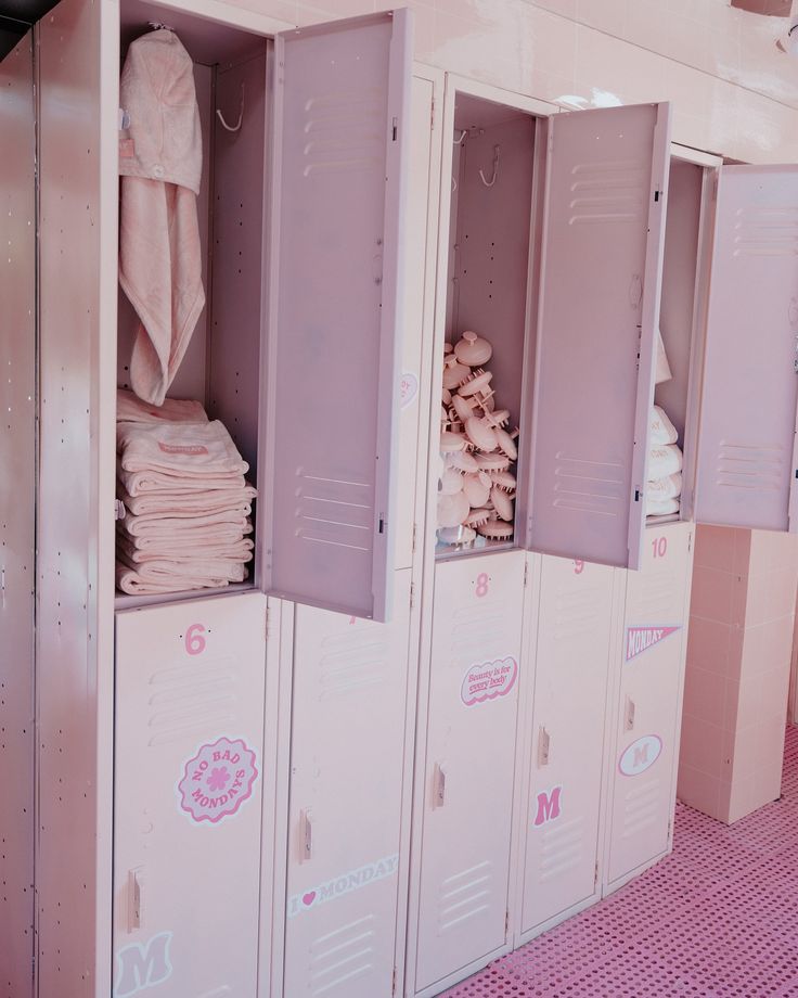 the lockers are all pink and have white towels on them, but no one is in it