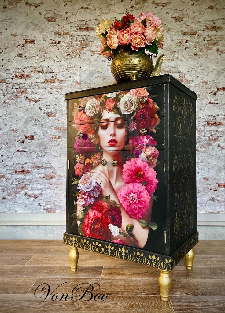 a cabinet with flowers painted on it and a vase full of flowers sitting on top