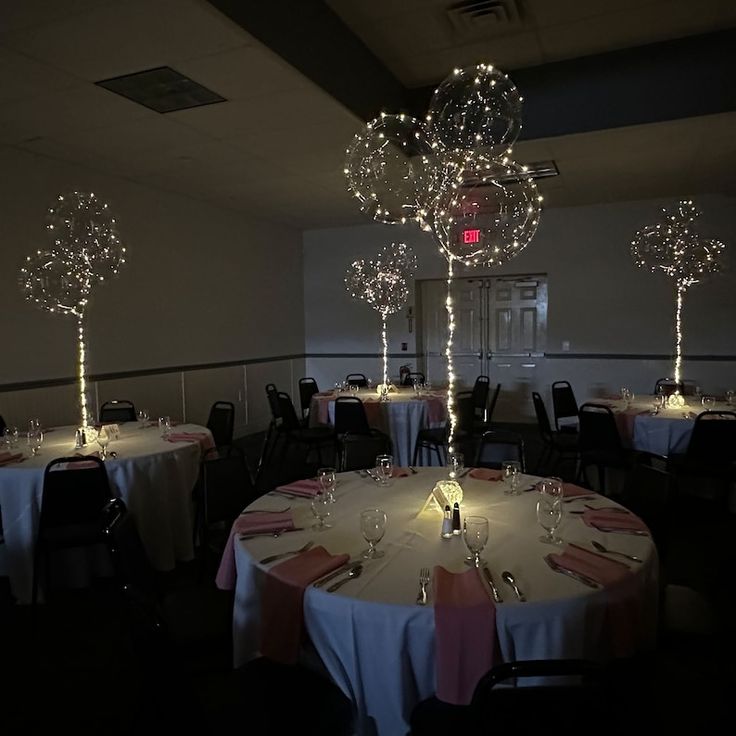 the tables are set with white tablecloths and lighted centerpieces