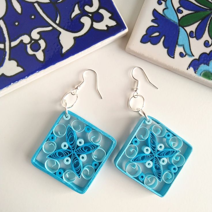 a pair of blue earrings sitting on top of a table